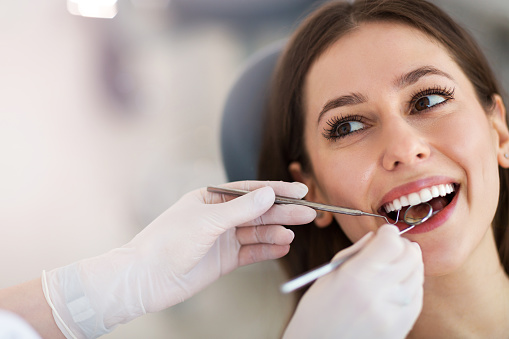 Image of a woman getting a dental exam at Singing River Dentistry.