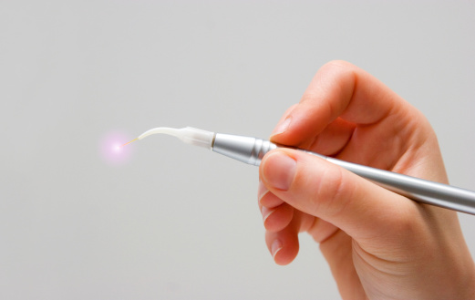 Hand holding a dental laser like those used at Singing River Dentistry