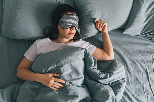 woman sleeping with mask over her eyes woman sleeping with mask over her eyes