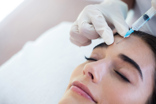 A woman receiving Botox injections from a doctor