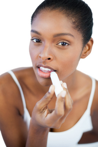 Black woman applying lip balm