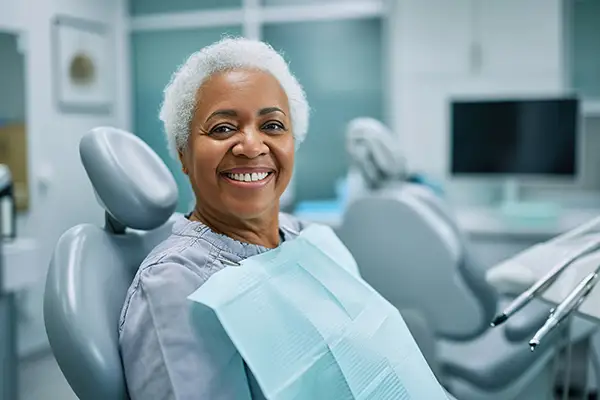 A smiling senior woman in dental chair ready and waiting for her dental procedure.